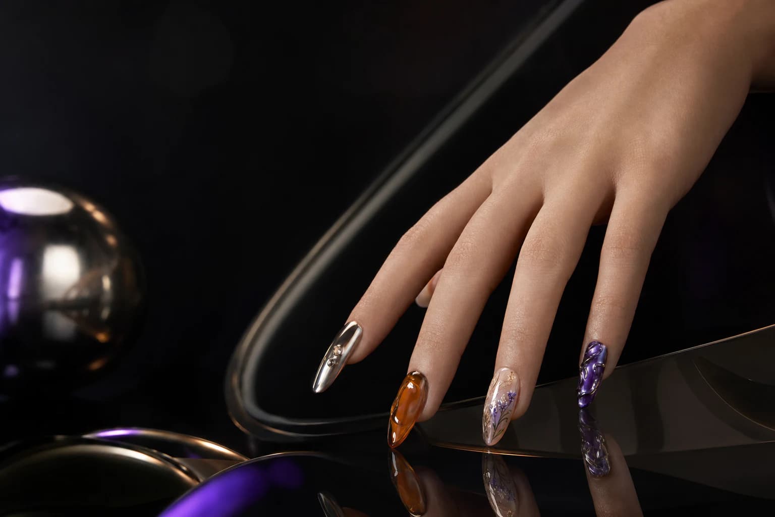 A couture press-on nail campaign photographed on a sculptural black lacquer set